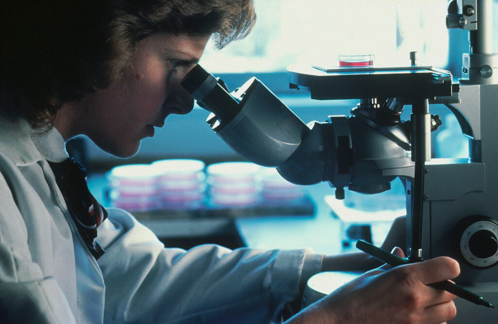 Una mujer utilizando un microscopio en un laboratorio